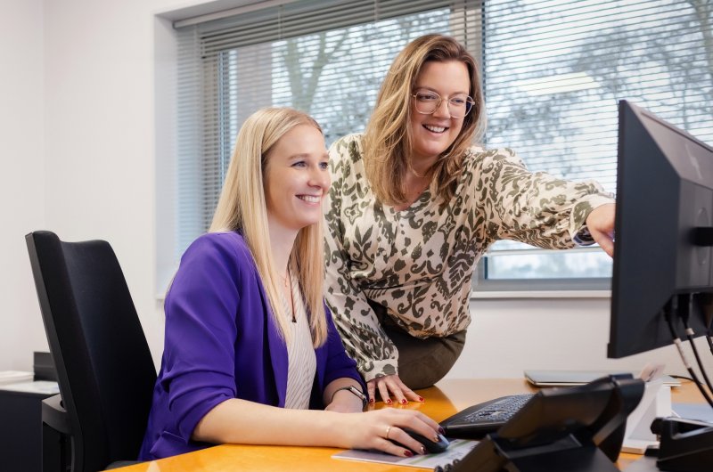 Notaris-Daniëlle-Katoen-achter-een-computerscherm-met-een-collega